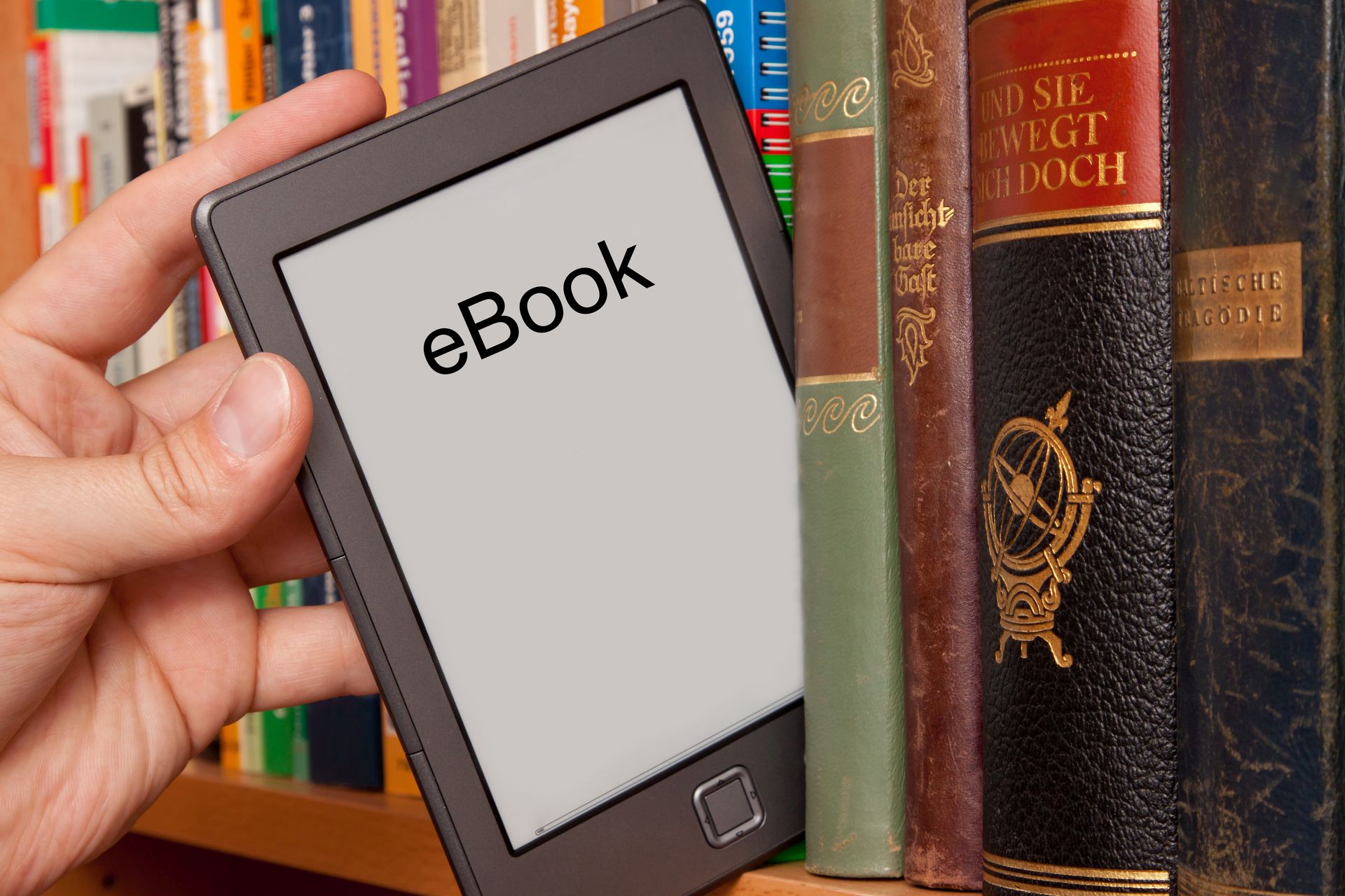 Foto einer Person, die ein eBook aus einem B&uuml;cherregal herauszieht.
