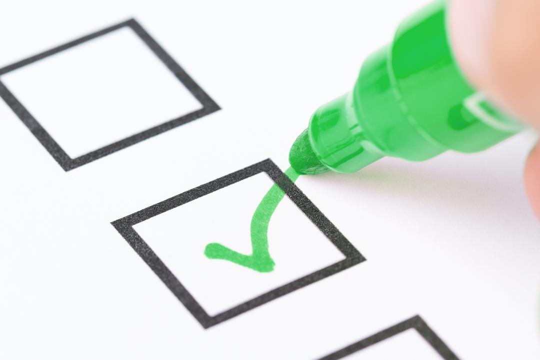 Foto einer Checkliste, die mit einem gr&uuml;nen Stift abgehakt wird.